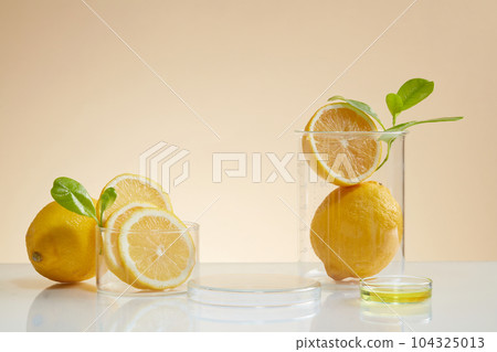 Lemon slices is contained inside beakers, displayed with a petri dish of yellow liquid. Round podium with vacant space to show your cosmetic product Lemon slices is contained inside beakers, displayed with a petri dish of yellow liquid. Round podium with vacant space to show your cosmetic product 104325013