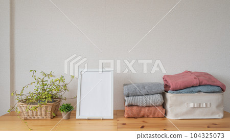 Folded winter clothes and white frame | Laundry / change of clothes image Folded winter clothes and white frame | Laundry / change of clothes image 104325073