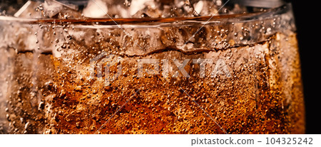 Splashing of Cola and Ice. Cola soda and ice splashing fizzing or floating up to top of surface. Close up of ice in cola water. Texture of carbonate drink with bubbles in glass. Cold drink background Splashing of Cola and Ice. Cola soda and ice splashing fizzing or floating up to top of surface. Close up of ice in cola water. Texture of carbonate drink with bubbles in glass. Cold drink background 104325242