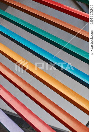 Multicolored wooden rails, lilac red orange yellow blue green wood planks abstract background. 104325265