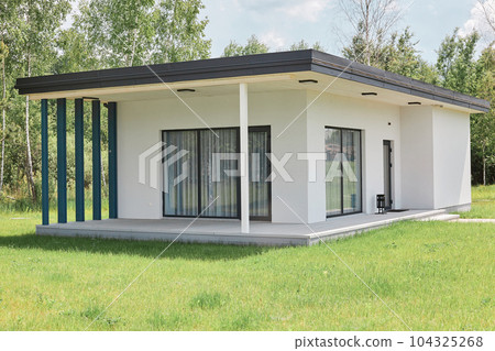 Big white house for rest with big windows and terrace and green lawn palce for recreation on holiday modern bulding for weekend resting. 104325268