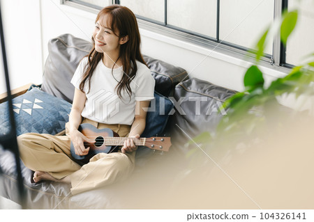 一個女人在玩夏威夷四弦琴 一個女人在玩夏威夷四弦琴 104326141