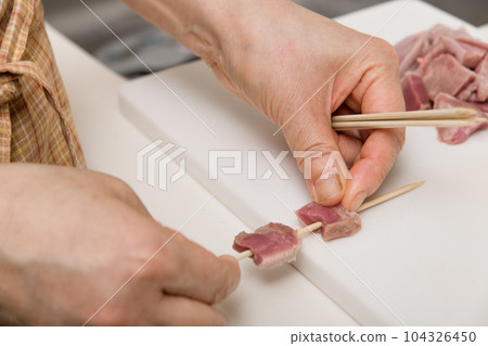 [Housewife skewering yakitori pork tongue] 104326450