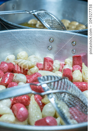 Deep fried meatballs and sausage in the pan, Popular Thai street food. 104327738