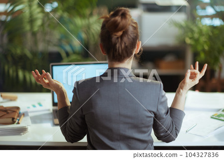 business owner woman in grey business suit at work meditating 104327836