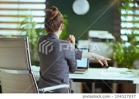 business owner woman in green office stretching hand 104327837