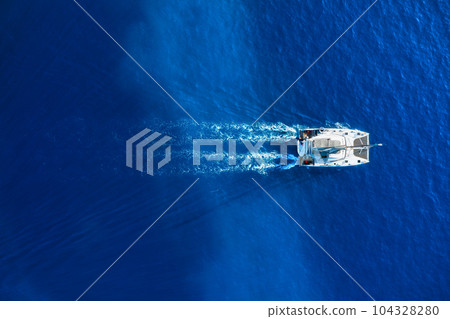 Drone view of a sailing yacht. Luxury transportation. Vacationing people. Vacation and holidays. Drone view of a sailing yacht. Luxury transportation. Vacationing people. Vacation and holidays. 104328280
