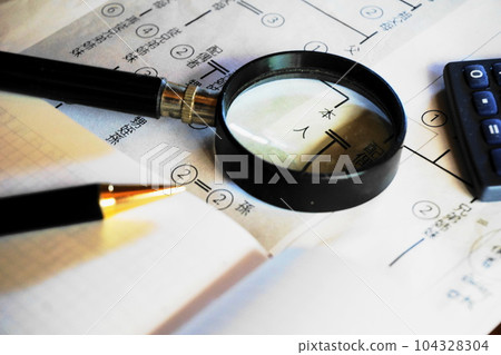 A magnifying glass and a pen over an isometric diagram 104328304