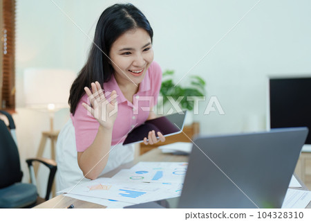 Portrait of a beautiful Asian teenage girl using computer for video conferencing at office. 104328310