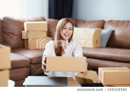 Starting small business entrepreneur of independent Asian female online seller packing products to send to customers and SME delivery concept. Starting small business entrepreneur of independent Asian female online seller packing products to send to customers and SME delivery concept. 104328560
