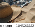 Wicker straw hat and blue white sarong pareo on beach sand. Summer sea vacation concept 104328882