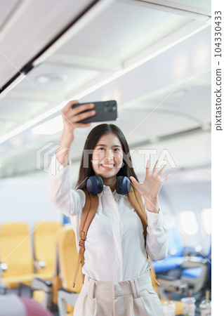Asian business woman passenger sitting on business class luxury plane while working using smart phone mobile talking or video conference and travel concept. Asian business woman passenger sitting on business class luxury plane while working using smart phone mobile talking or video conference and travel concept. 104330433