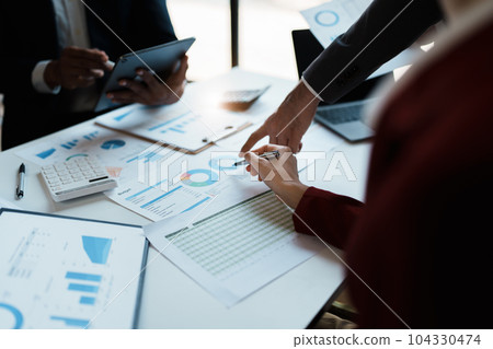 Team business adviser meeting to analyze and discuss the situation on the financial report n the meeting room with using documents, calculator, computer laptop in work Team business adviser meeting to analyze and discuss the situation on the financial report n the meeting room with using documents, calculator, computer laptop in work 104330474