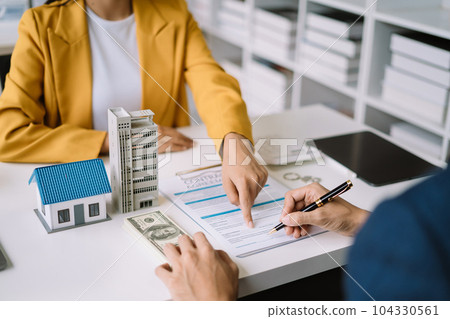 Real estate broker agent presenting and consult to customer to decision making sign insurance form agreement, home model, concerning mortgage loan offer. 104330561