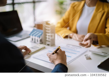 Real estate broker agent presenting and consult to customer to decision making sign insurance form agreement, home model, concerning mortgage loan offer. Real estate broker agent presenting and consult to customer to decision making sign insurance form agreement, home model, concerning mortgage loan offer. 104330562