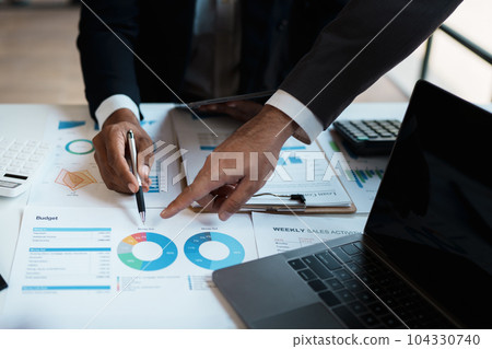 Team business adviser meeting to analyze and discuss the situation on the financial report n the meeting room with using documents, calculator, computer laptop in work Team business adviser meeting to analyze and discuss the situation on the financial report n the meeting room with using documents, calculator, computer laptop in work 104330740
