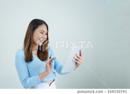 Portrait of asian woman using tablet relaxing at home. Portrait of asian woman using tablet relaxing at home. 104330741