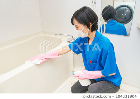 A woman in work clothes cleaning the bathroom 104331904