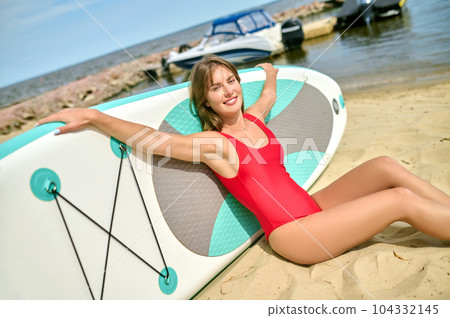 Attractive woman on sandy beach, girl loves water sports, surfing relaxing at sea resort. Attractive woman on sandy beach, girl loves water sports, surfing relaxing at sea resort. 104332145