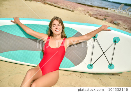 Slim woman surfer in red swimwear enjoying time at beach and surfing, extreme sport summer vacation. Slim woman surfer in red swimwear enjoying time at beach and surfing, extreme sport summer vacation. 104332146