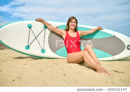 Attractive woman on sandy beach, girl loves water sports, surfing relaxing at sea resort. Attractive woman on sandy beach, girl loves water sports, surfing relaxing at sea resort. 104332147