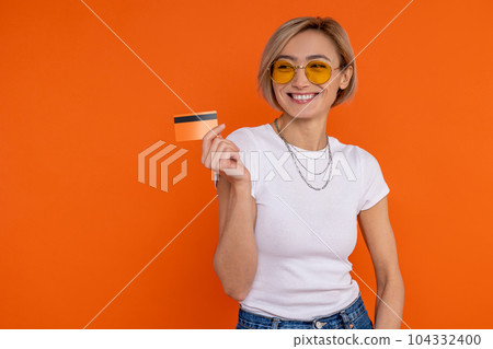 Charming smiling happy woman in white t shirt showing credit card banking 104332400