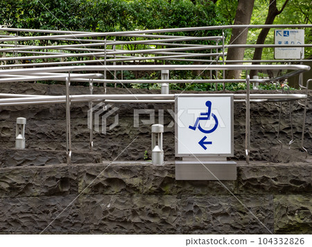 Eliminates the step to the facility entrance - wheelchair ramp and pictogram installed outdoors 104332826