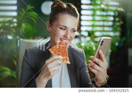 smiling woman worker in green office using phone 104332925