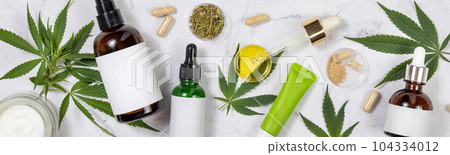 Cosmetics with blank labes, Pipette with CBD oil, hemp capsules and green cannabis leaves Cosmetics with blank labes, Pipette with CBD oil, hemp capsules and green cannabis leaves 104334012