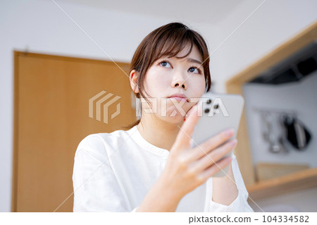 A woman watching a smartphone 104334582