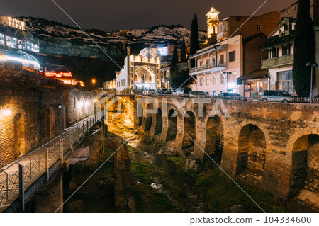 Tbilisi, Georgia, Night Scenic View Of Abanotubani - Bath District - Is The Ancient District Of Tbilisi, Georgia. Sulfuric Baths, rvier in canyon Tbilisi, Georgia, Night Scenic View Of Abanotubani - Bath District - Is The Ancient District Of Tbilisi, Georgia. Sulfuric Baths, rvier in canyon 104334600
