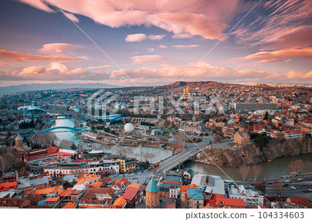 Tbilisi, Georgia. Top View Of Famous Landmarks In spring sunset Evening. Georgian Capital Skyline Cityscape Tbilisi, Georgia. Top View Of Famous Landmarks In spring sunset Evening. Georgian Capital Skyline Cityscape 104334603
