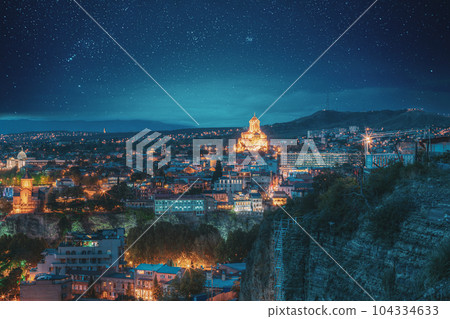 Tbilisi, Georgia. Concert Hall, Metekhi Church, Presidential Administration Palace, Sameba Complex, Holy Trinity Cathedral In Night Illumination Under Amazing Blue Bright Night Starry Sky 104334633