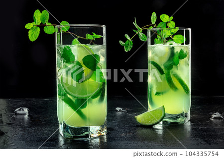 Mojito cocktail. Summer cold drink with lime, fresh mint, and ice. Cool beverage 104335754