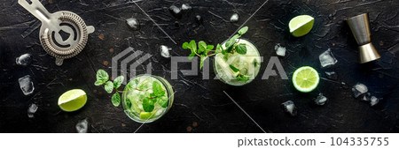Mojito cocktail. Summer cold drink with lime, fresh mint, and ice. Cool beverage 104335755