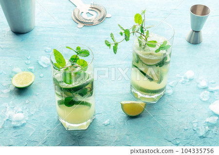 Mojito cocktail. Summer cold drink with lime, fresh mint, and ice. Cool beverage Mojito cocktail. Summer cold drink with lime, fresh mint, and ice. Cool beverage 104335756