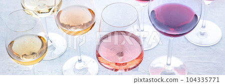 Wine glasses at a tasting. Rose, red, and white wine, drinks on a table 104335771