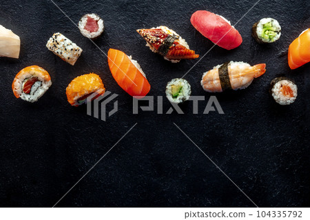 Sushi, shot from the top. Rolls, maki, nigiri on a black slate background Sushi, shot from the top. Rolls, maki, nigiri on a black slate background 104335792