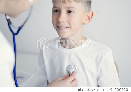 Doctor and happy smiling child boy patient at usual medical inspection in clinic. Medicine, healthcare concepts 104336360