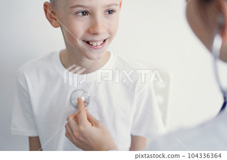 Doctor and happy smiling child boy patient at usual medical inspection in clinic. Medicine, healthcare concepts 104336364
