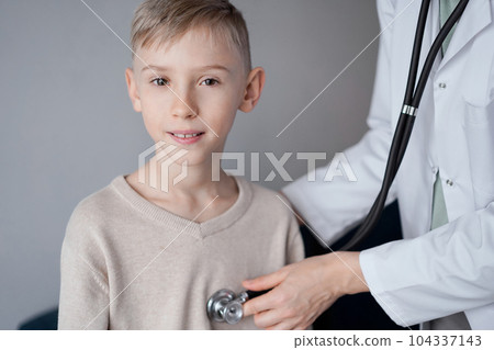 Doctor and happy smiling child boy patient at home medical inspection. Medicine, healthcare concepts Doctor and happy smiling child boy patient at home medical inspection. Medicine, healthcare concepts 104337143