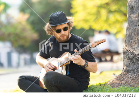Man playing guitar on the street Man playing guitar on the street 104337218
