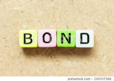 Color alphabet letter block in word bond on wood background 104337366