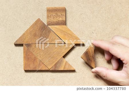 Wooden tangram puzzle wait to fulfill home shape for build dream home, happy life, house or mortgage investment concept 104337780
