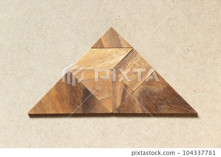 Wooden tangram in triangle shape on wood background 104337781