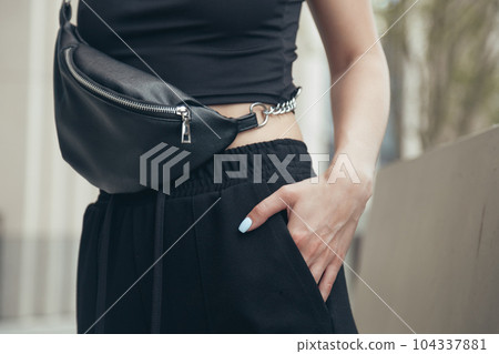 Woman in Black Wearing Black Genuine Leather Waist Bag. Urban fashion Woman in Black Wearing Black Genuine Leather Waist Bag. Urban fashion 104337881