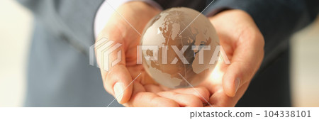 Hands of businessman in suit holding glass globe of earth closeup Hands of businessman in suit holding glass globe of earth closeup 104338101