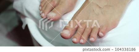 Female feet with polished nails on pedicure closeup 104338186