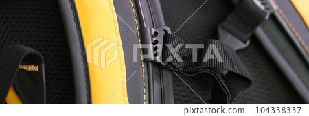 Shoulder straps in yellow and black backpack for comfortable carrying on back closeup Shoulder straps in yellow and black backpack for comfortable carrying on back closeup 104338337