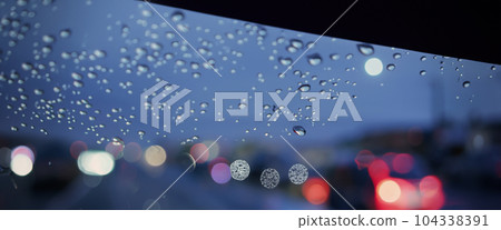 Driving in raining. Rain on car windshield or car window in rainy season and blurry traffic road in background. Rain drops on car mirror. Road in rain. Drizzle raining decreases driving visibility. Driving in raining. Rain on car windshield or car window in rainy season and blurry traffic road in background. Rain drops on car mirror. Road in rain. Drizzle raining decreases driving visibility. 104338391